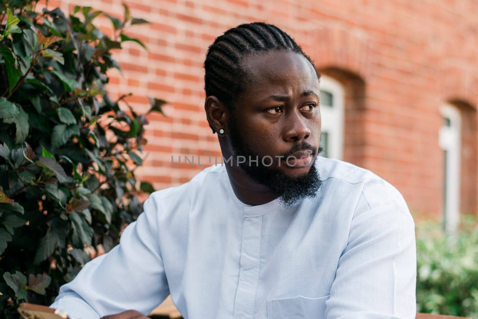 Portrait of a happy african american man wearing ethnic dashiki clothes outdoor in summer street wall. Millennial generation student and youth. Copy space by Satura86
