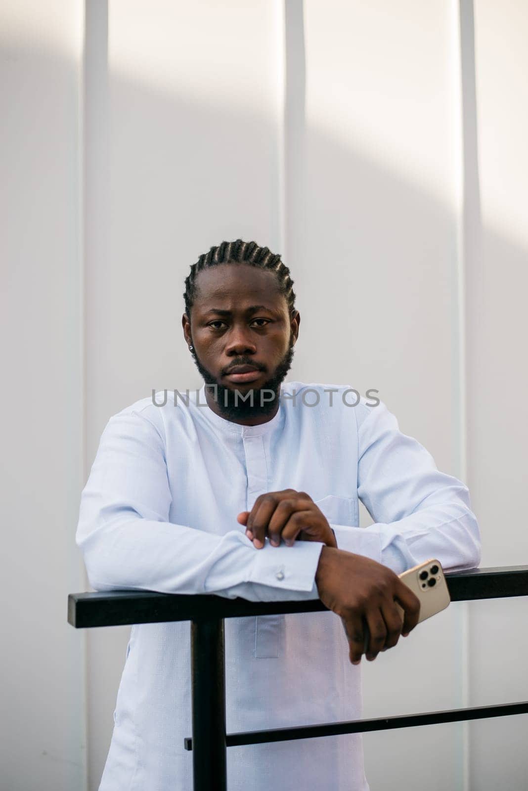 Cheerful male tourist portrait dress in white wear dashiki ethnic smiling at city street or small town background. African American travel model have free time. Millennial generation and gen z people by Satura86