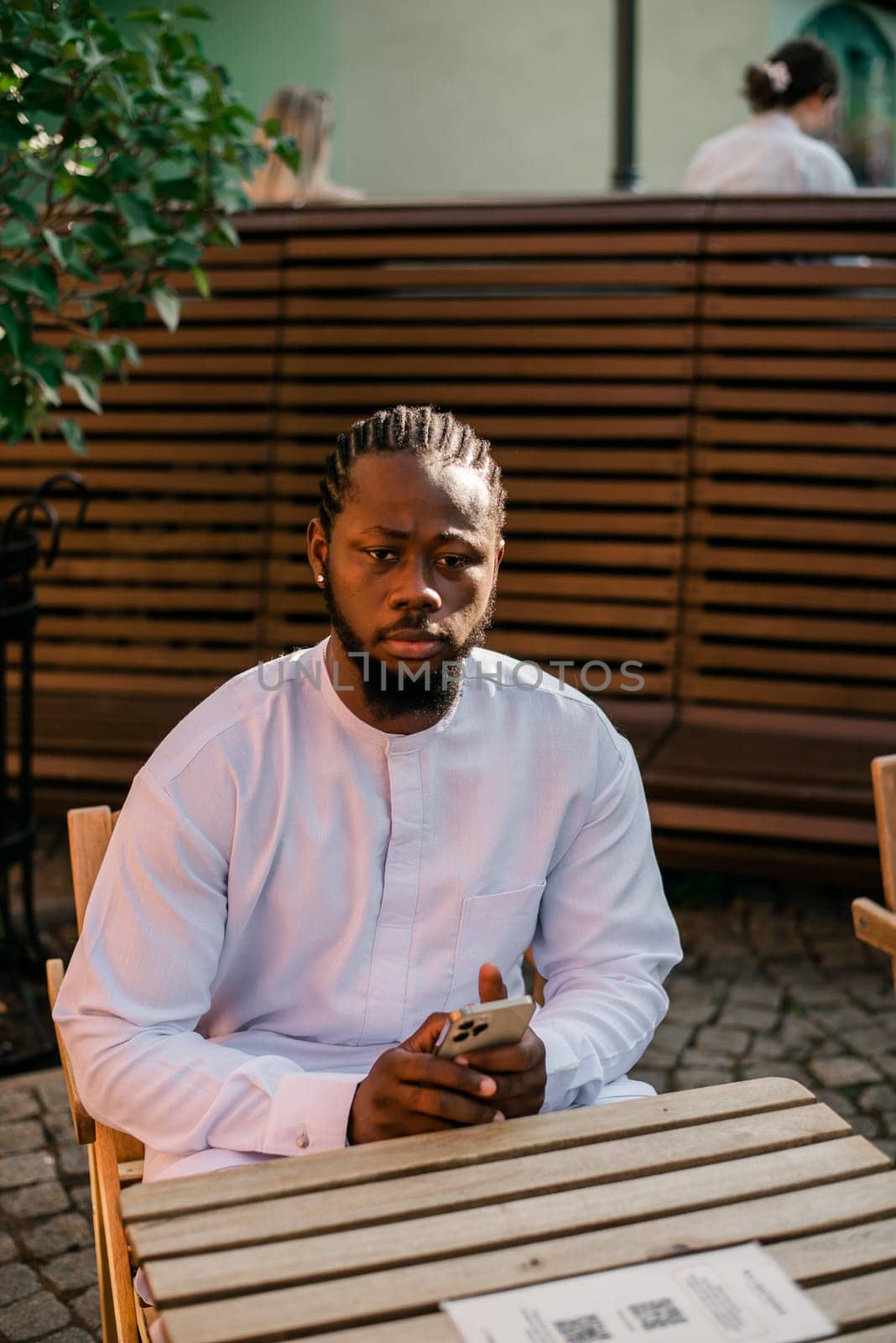 Cheerful male tourist portrait dress in white wear dashiki ethnic smiling at city street or small town background. African American travel model have free time. Millennial generation and gen z people.