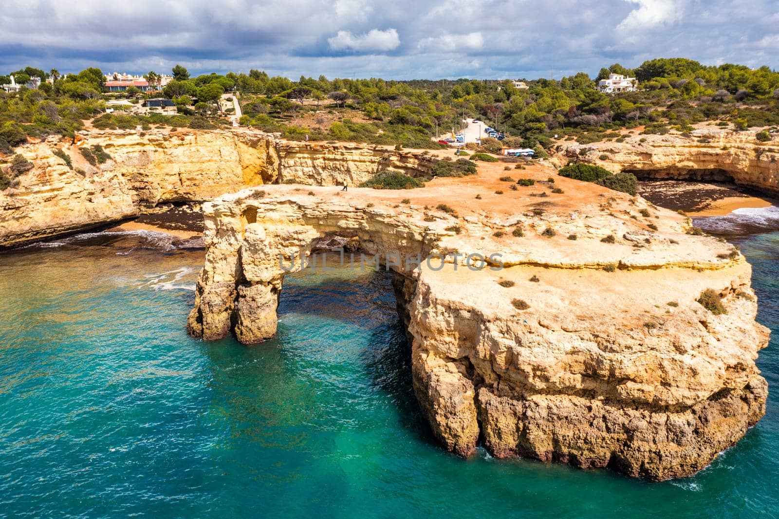 Natural arch above ocean, Arco de Albandeira, Algarve, Portugal. Stone arch at Praia de Albandeira, Lagoa, Algarve, Portugal. View of the natural arch Arco da Albandeira in the Algarve, Portugal.