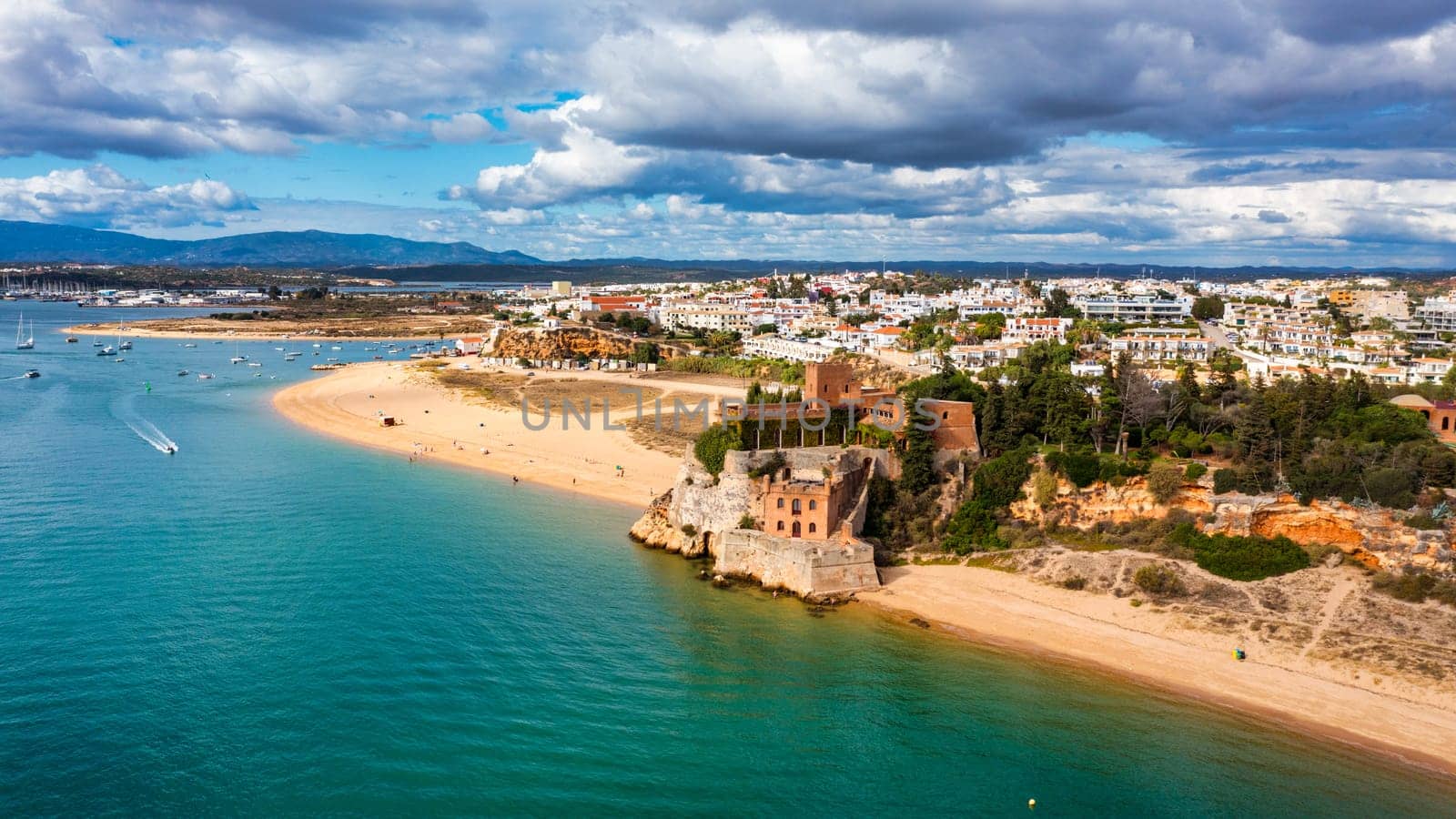 Ferragudo with the Praia Grande (the main beach) and the river Rio Arade, Algarve, Portugal. Beautiful seascape with beach, cave and ocean, Praia Grande beach, Ferragudo, Lagoa, Algarve, Portugal.