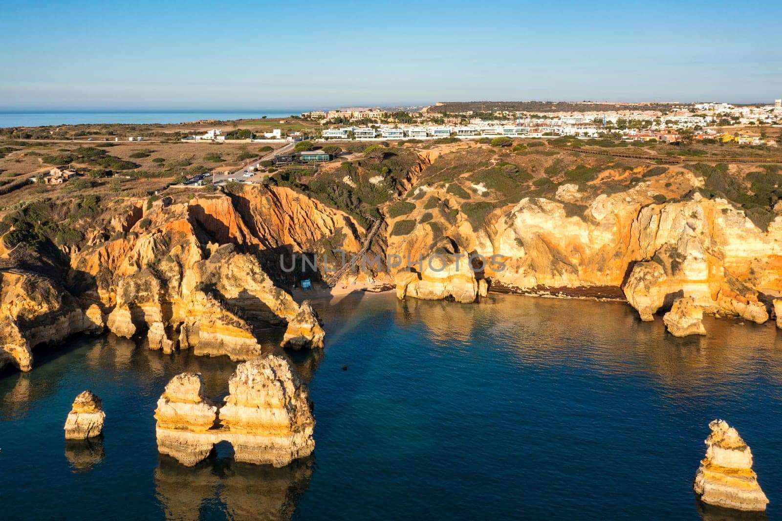 Panoramic view, Ponta da Piedade near Lagos in Algarve, Portugal. Cliff rocks and tourist boat on sea at Ponta da Piedade, Algarve region, Portugal. Ponta da Piedade, Algarve region, Portugal.