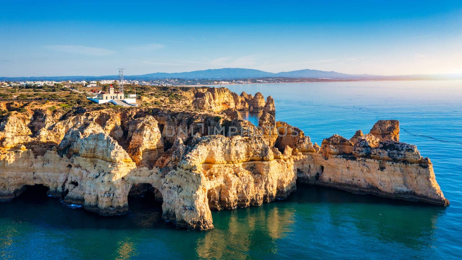 Panoramic view, Ponta da Piedade near Lagos in Algarve, Portugal. Cliff rocks and tourist boat on sea at Ponta da Piedade, Algarve region, Portugal. Ponta da Piedade, Algarve region, Portugal.