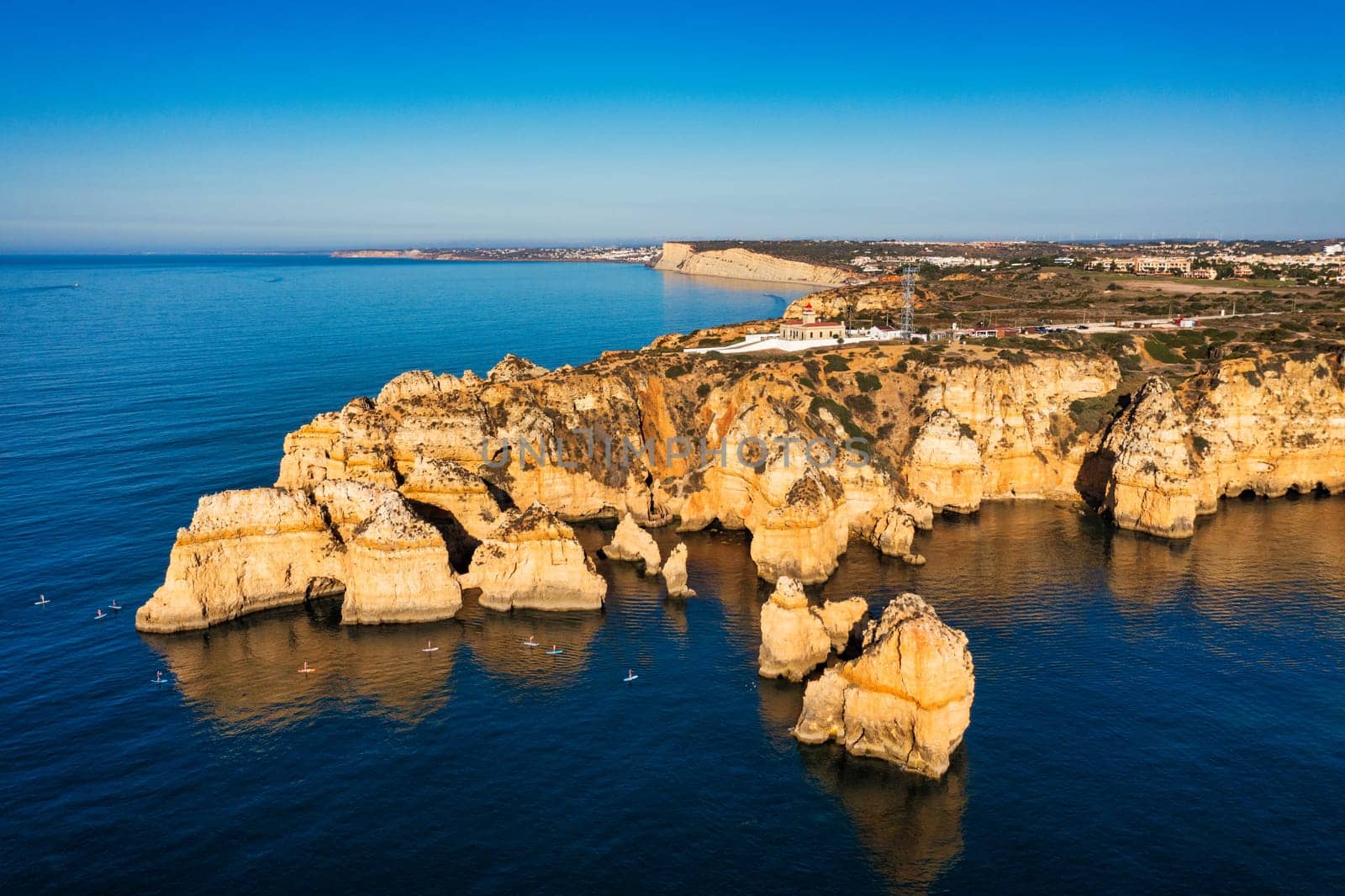 Panoramic view, Ponta da Piedade near Lagos in Algarve, Portugal. Cliff rocks and tourist boat on sea at Ponta da Piedade, Algarve region, Portugal. Ponta da Piedade, Algarve region, Portugal.