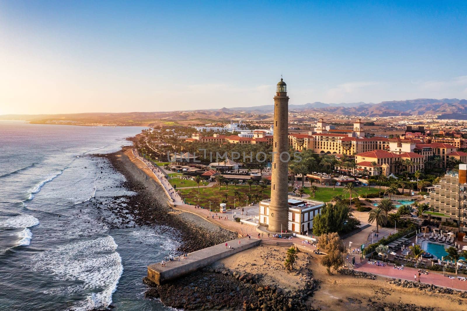 Lighthouse of Maspalomas at Gran Canaria Island known as Faro de Maspalomas at sunset. Seascape with lighthouse and Maspalomas beach. Gran Canaria, Canary Islands, Spain