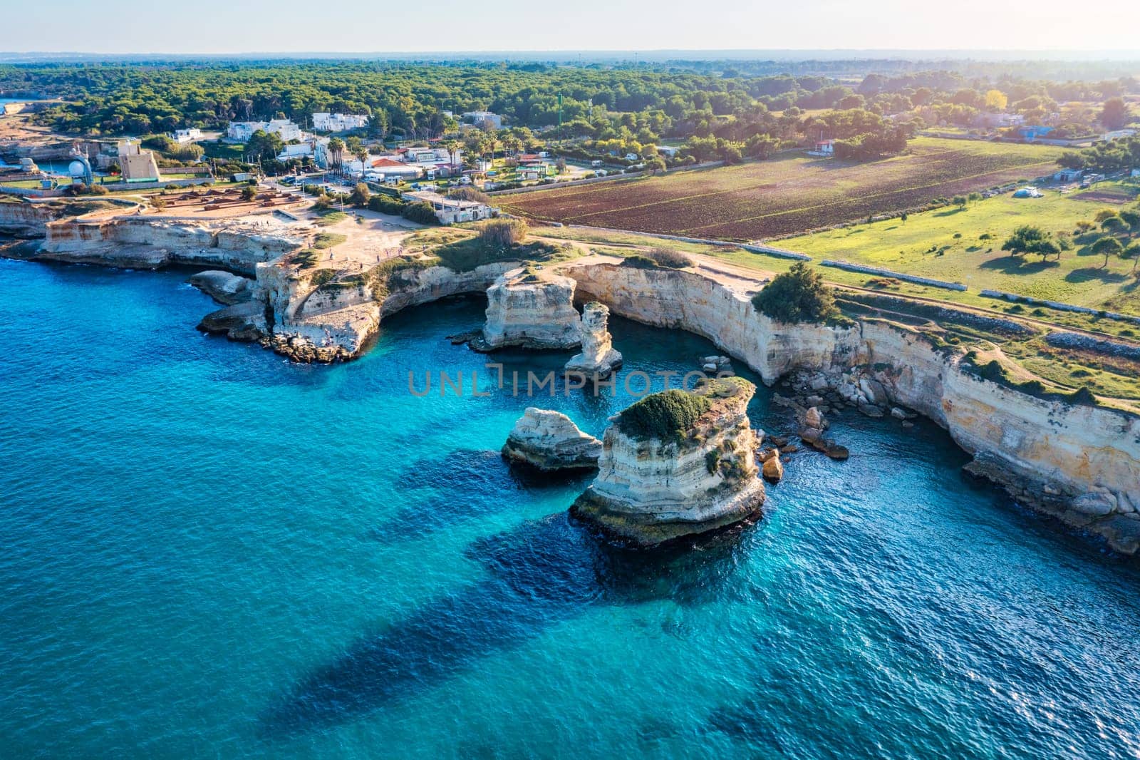 Stunning seascape with cliffs rocky arch and stacks (Faraglioni) at Torre Sant Andrea, Salento coast, Puglia region, Italy. Beautiful cliffs and sea stacks of Sant'Andrea, Salento, Apulia, Italy