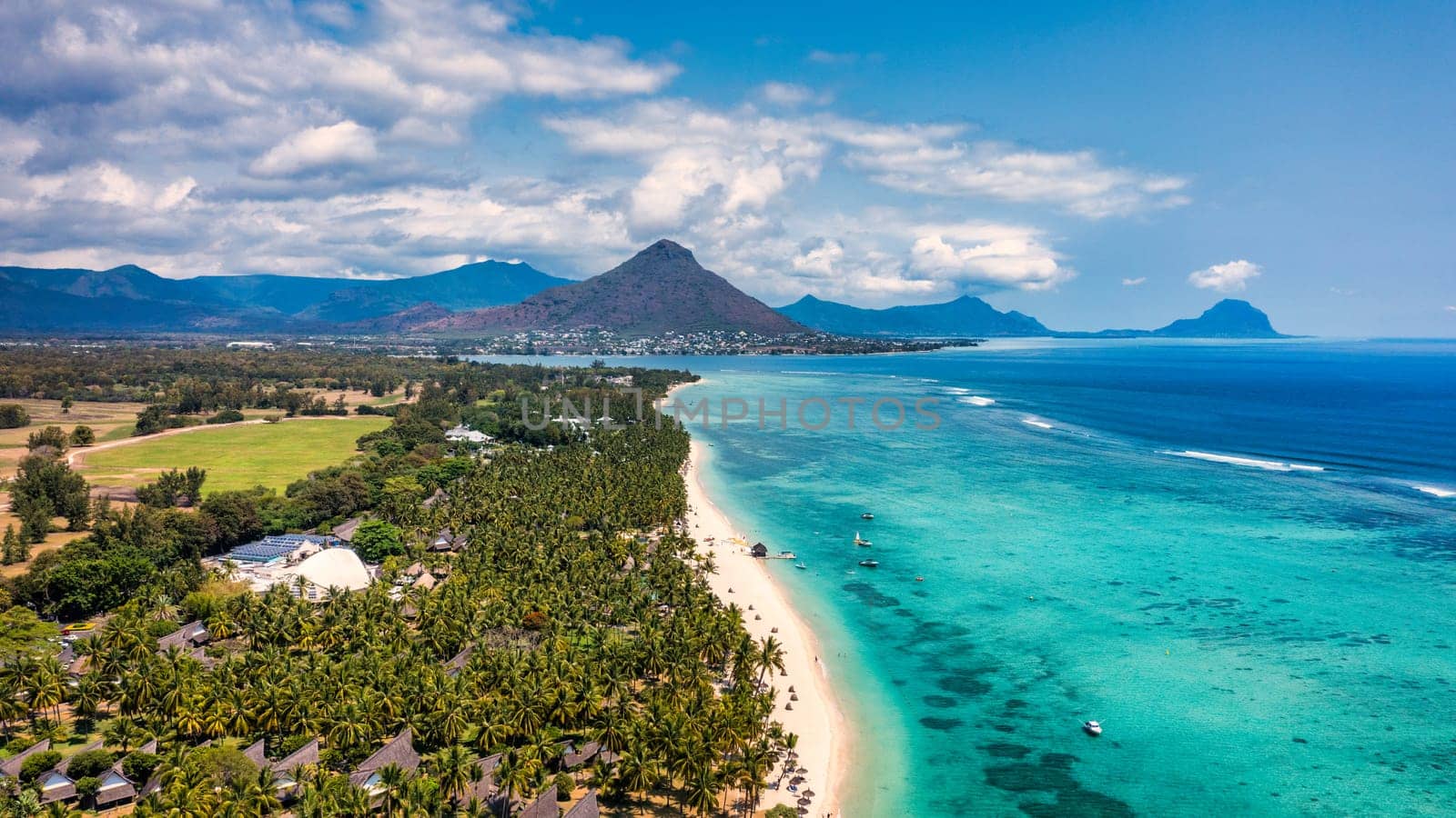 Beach of Flic en Flac with Piton de la Petite Riviere Noire Mauritius. Beautiful Mauritius Island with gorgeous beach Flic en Flac, aerial view from drone. Flic en Flac Beach, Mauritius Island.