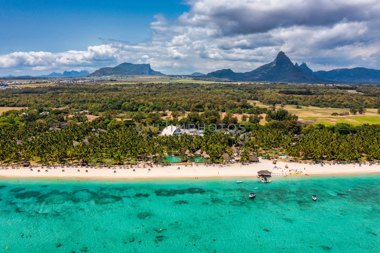 Beach of Flic en Flac with beautiful peaks in the background, Mauritius. Beautiful Mauritius Island with gorgeous beach Flic en Flac, aerial view from drone. Flic en Flac Beach, Mauritius Island.