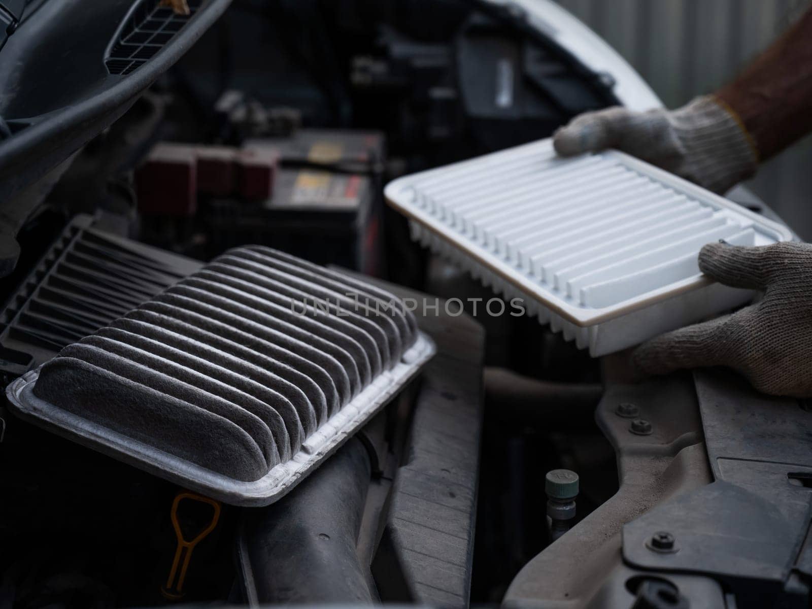 The master changes the air filter in the car engine. by mrwed54