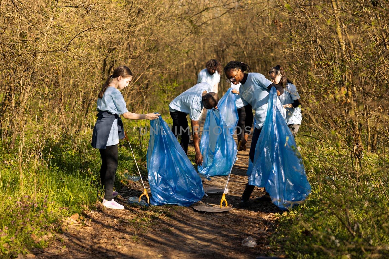 Group of diverse volunteers collecting rubbish and plastic waste by DCStudio