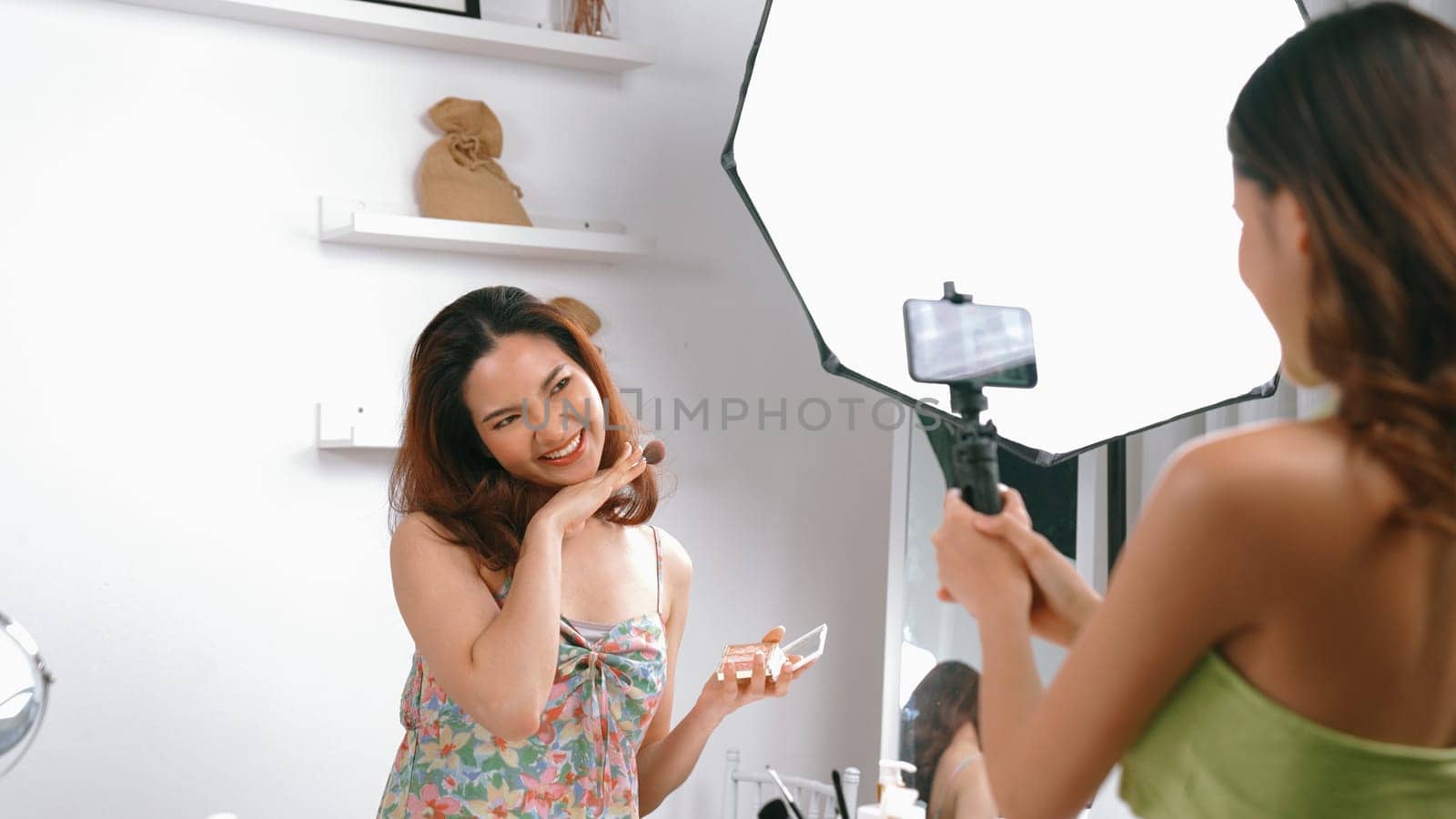 Two influencer partner shoot live streaming vlog video review makeup social media or blog. Happy young girl with vivancy cosmetics studio lighting for marketing recording session broadcasting online.