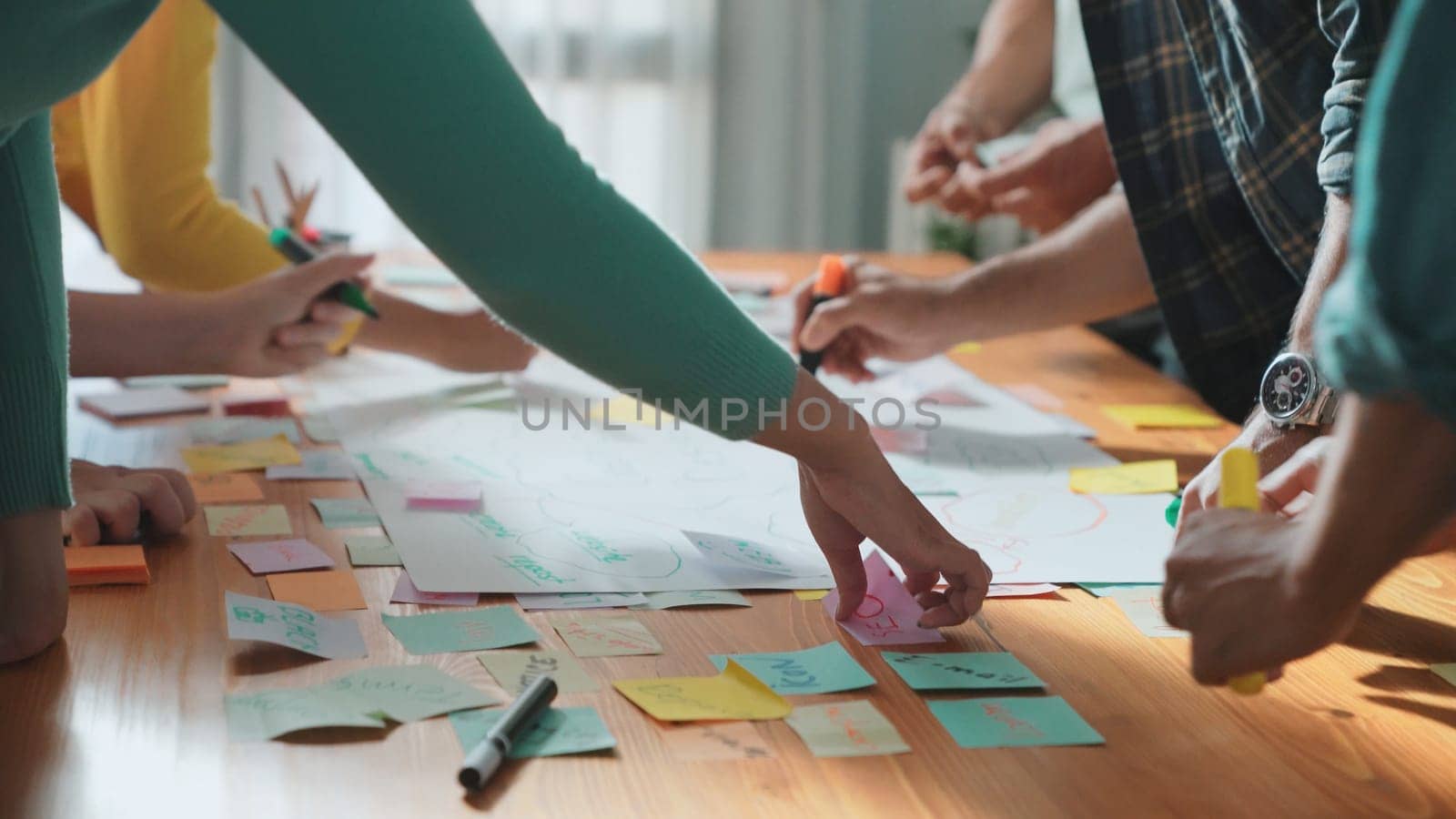 Close up of developer team using mind map to brainstorm idea. Top view of skilled group of business people working together writing marketing strategy by using markers and sticky notes. Symposium.