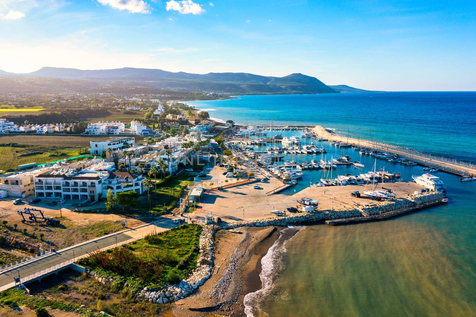 View of Latchi port, Akamas peninsula, Polis Chrysochous, Paphos, Cyprus. The Latsi harbour with boats and yachts, fish restaurant, promenade, beach tourist area and mountains, Latchi, Cyprus.