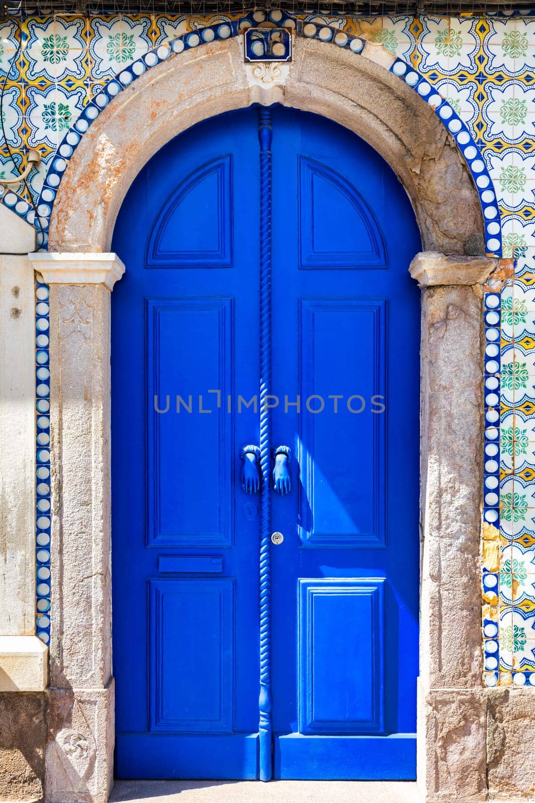 A blue door with a rope hanging from it, Tavira, Algarve, Portugal. by DaLiu