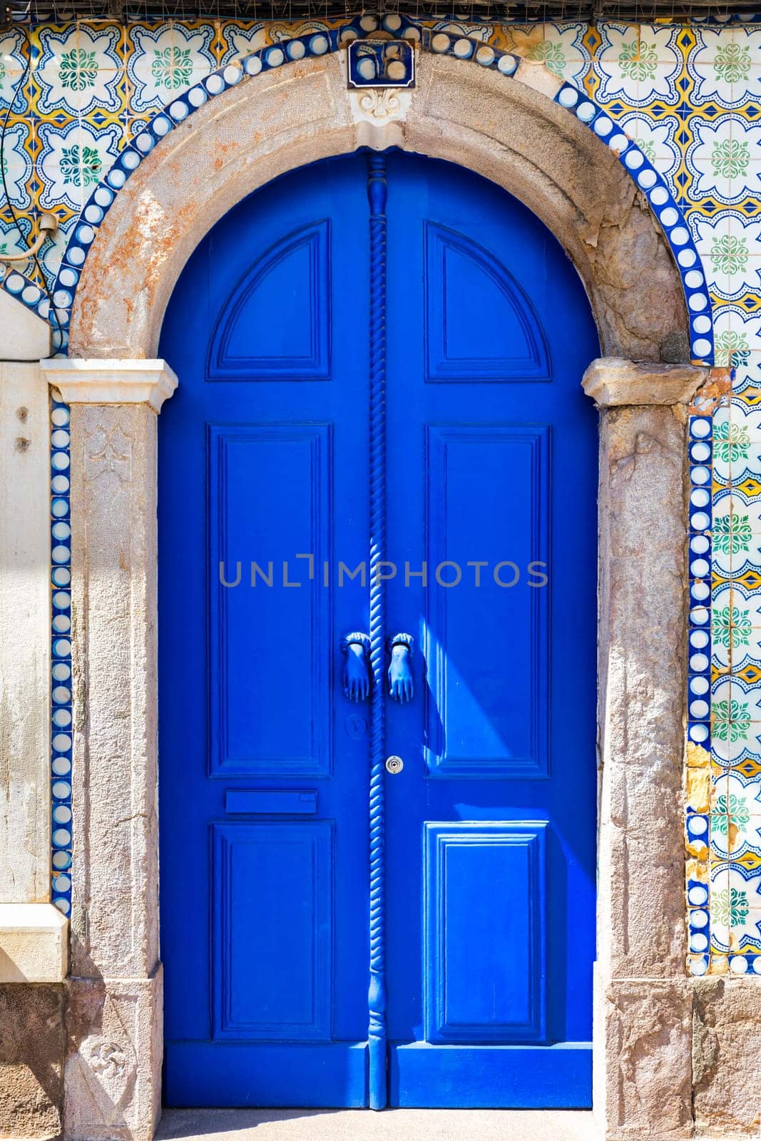 A blue door with a rope hanging from it, Tavira, Algarve, Portugal.