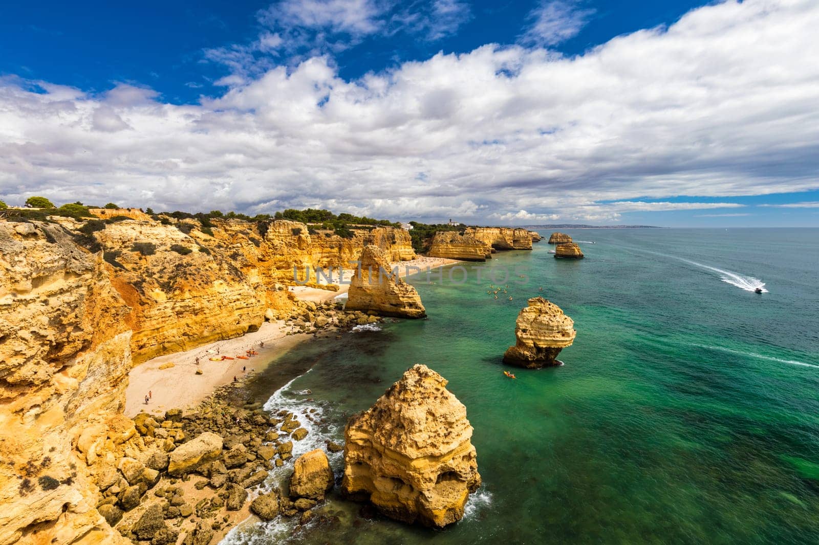 Natural caves at Marinha beach, Algarve Portugal. Rock cliff arches on Marinha beach and turquoise sea water on coast of Portugal in Algarve region. 