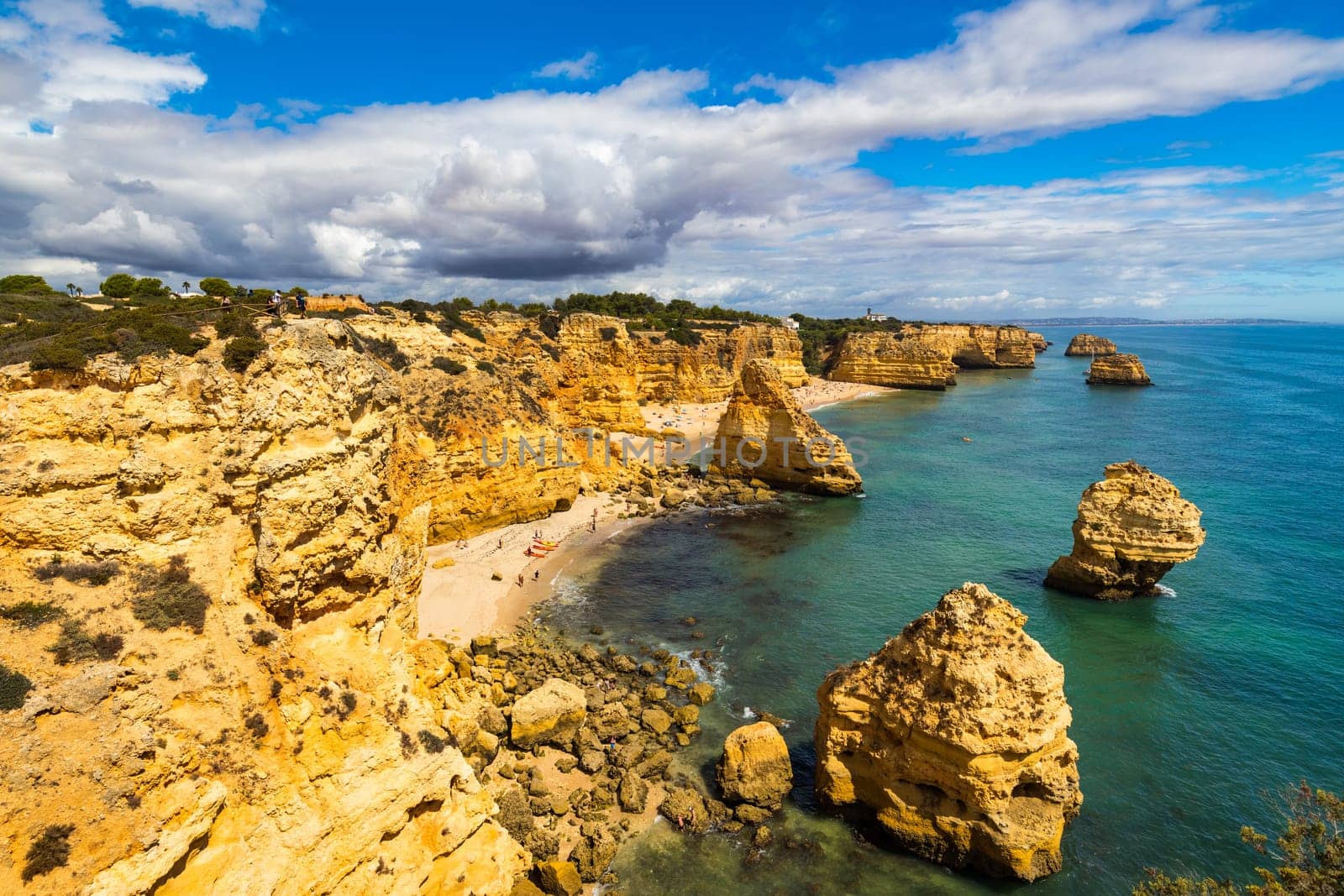 Natural caves at Marinha beach, Algarve Portugal. Rock cliff arches on Marinha beach and turquoise sea water on coast of Portugal in Algarve region. 