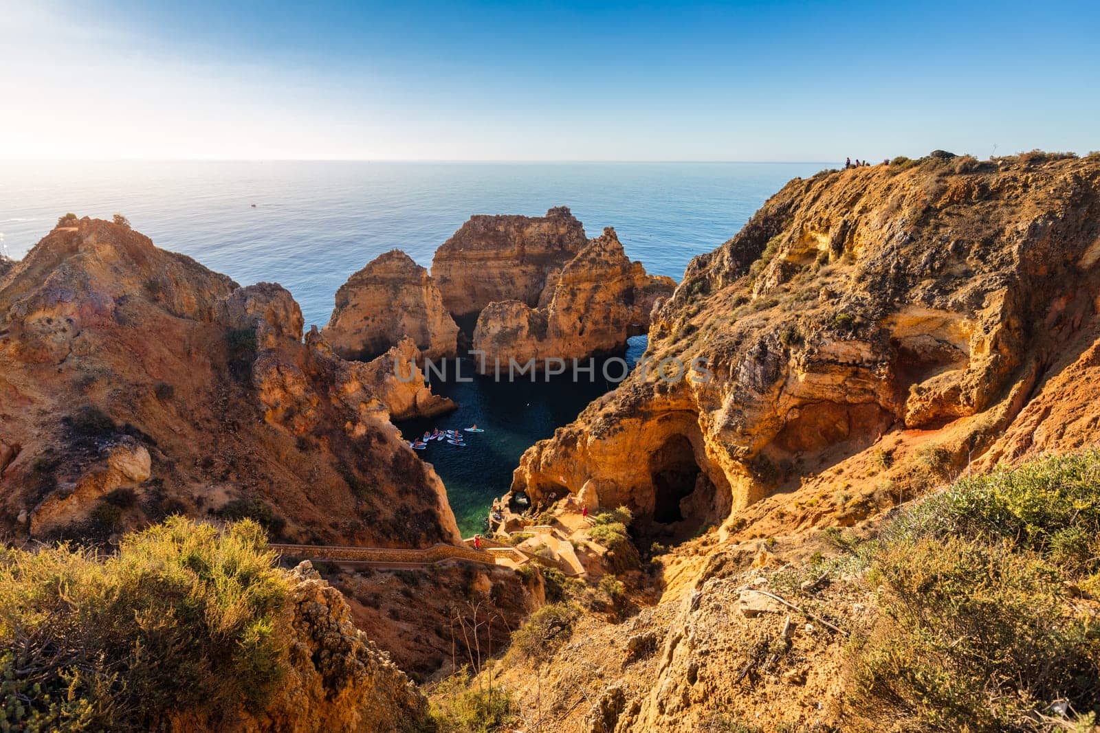 Panoramic view, Ponta da Piedade near Lagos in Algarve, Portugal. Cliff rocks and tourist boat on sea at Ponta da Piedade, Algarve region, Portugal. Ponta da Piedade, Algarve region, Portugal.