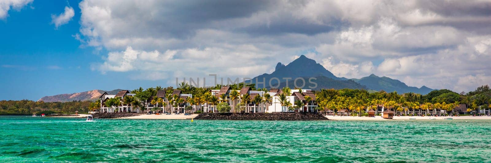 Tropical paradise, best beaches of Mauritius island, luxury resorts. Recreational tourism landscape. Luxurious beach resort with spa swimming pool and beach chairs or leisure loungers under umbrellas.