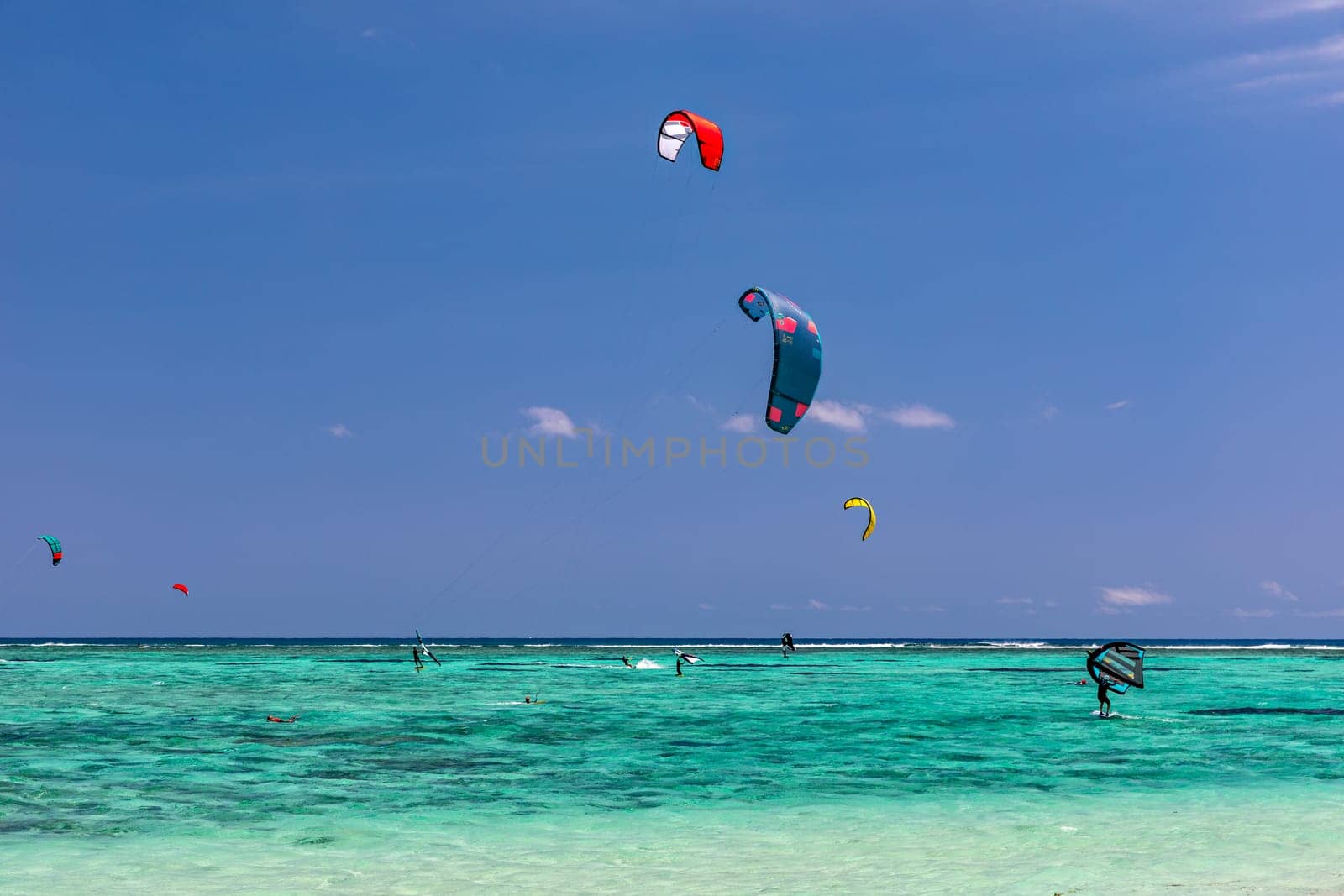 Kite surfers in the waters of Indian Ocean, Mauritius. Kite surfing in the clear waters of the Indian Ocean in Le Morne beach, Mauritius. Best Kite surfing experience at Mauritius island. by DaLiu