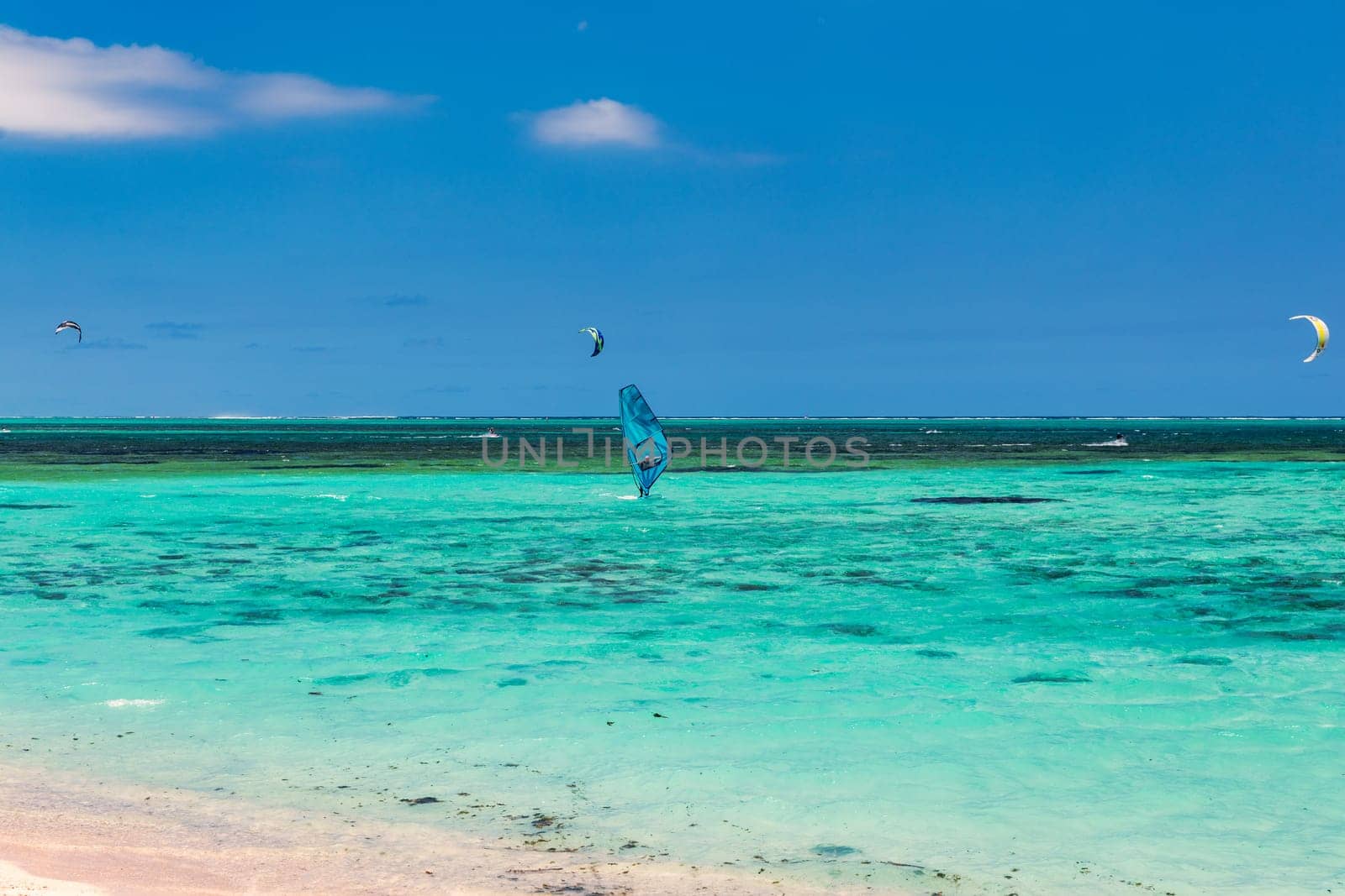 Kite surfers in the waters of Indian Ocean, Mauritius. Kite surfing in the clear waters of the Indian Ocean in Le Morne beach, Mauritius. Best Kite surfing experience at Mauritius island.