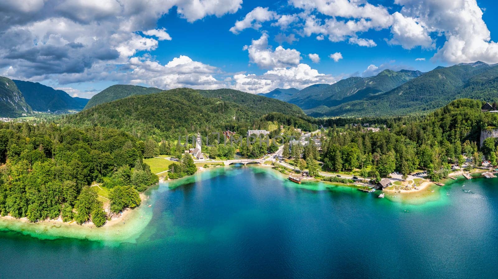 Aerial view of Bohinj lake in Julian Alps. Popular touristic destination in Slovenia. Bohinj Lake, Church of St John the Baptist. Triglav National Park, Julian Alps, Slovenia.  by DaLiu