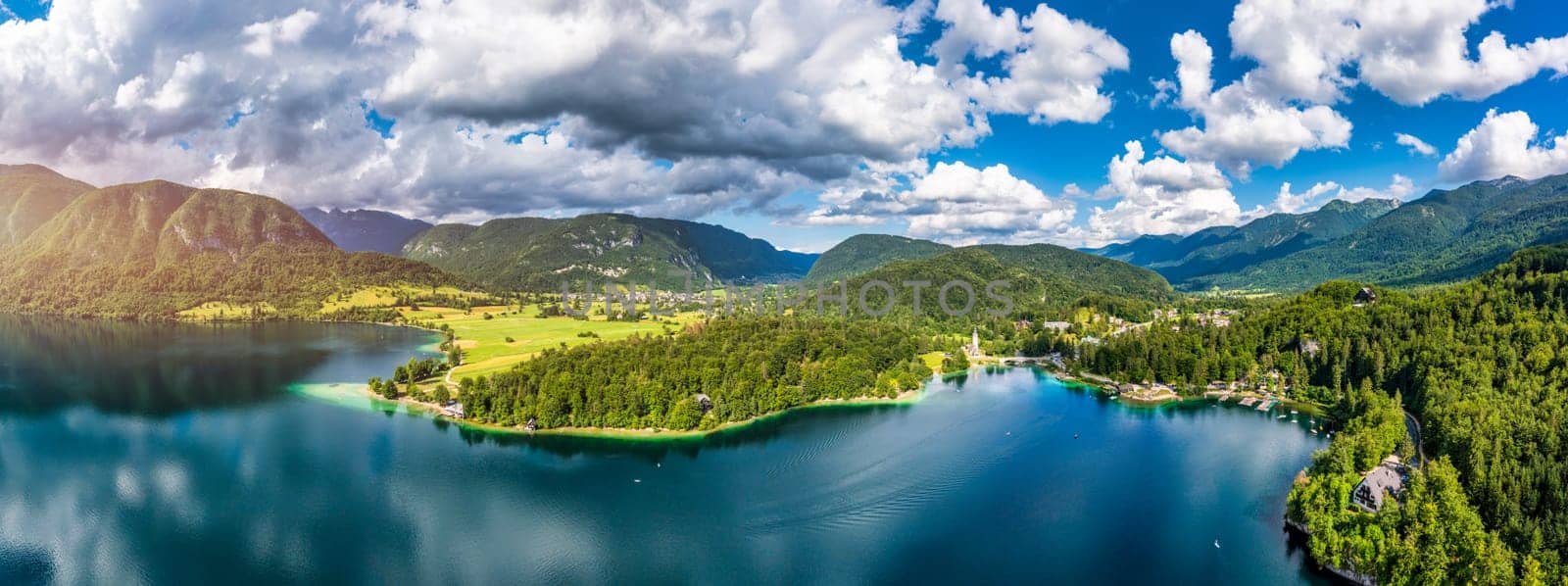 Aerial view of Bohinj lake in Julian Alps. Popular touristic destination in Slovenia. Bohinj Lake, Church of St John the Baptist. Triglav National Park, Julian Alps, Slovenia. 