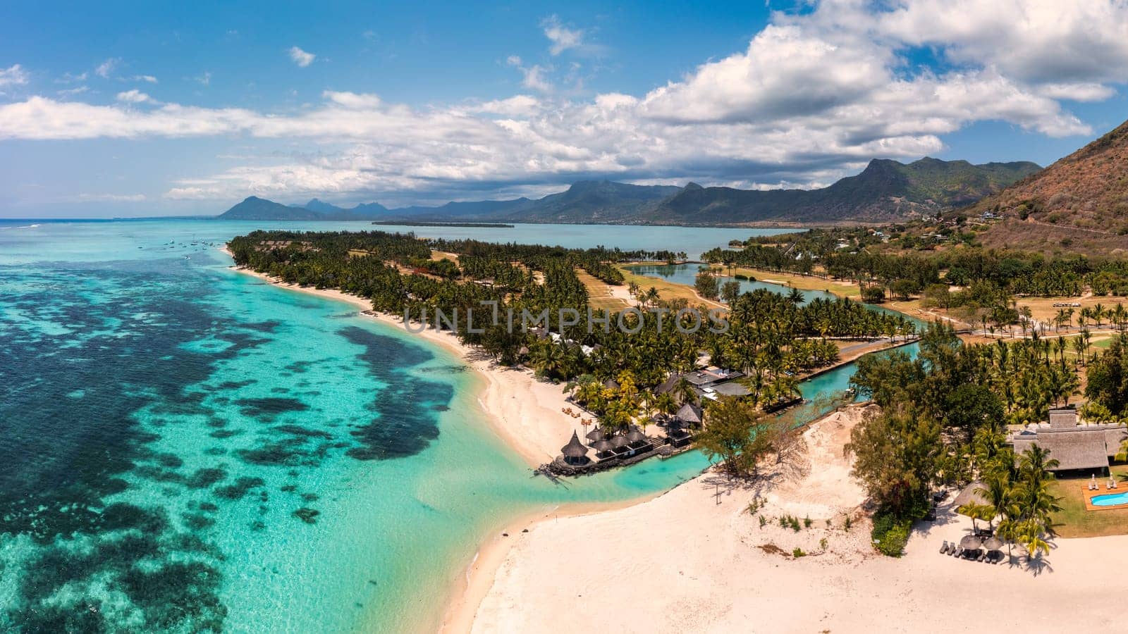 Beach with palm trees and umbrellas on Le morne beach in Mauriutius. Luxury tropical beach and Le Morne mountain in Mauritius. Le Morne beach with palm trees, white sand and luxury resorts, Mauritius