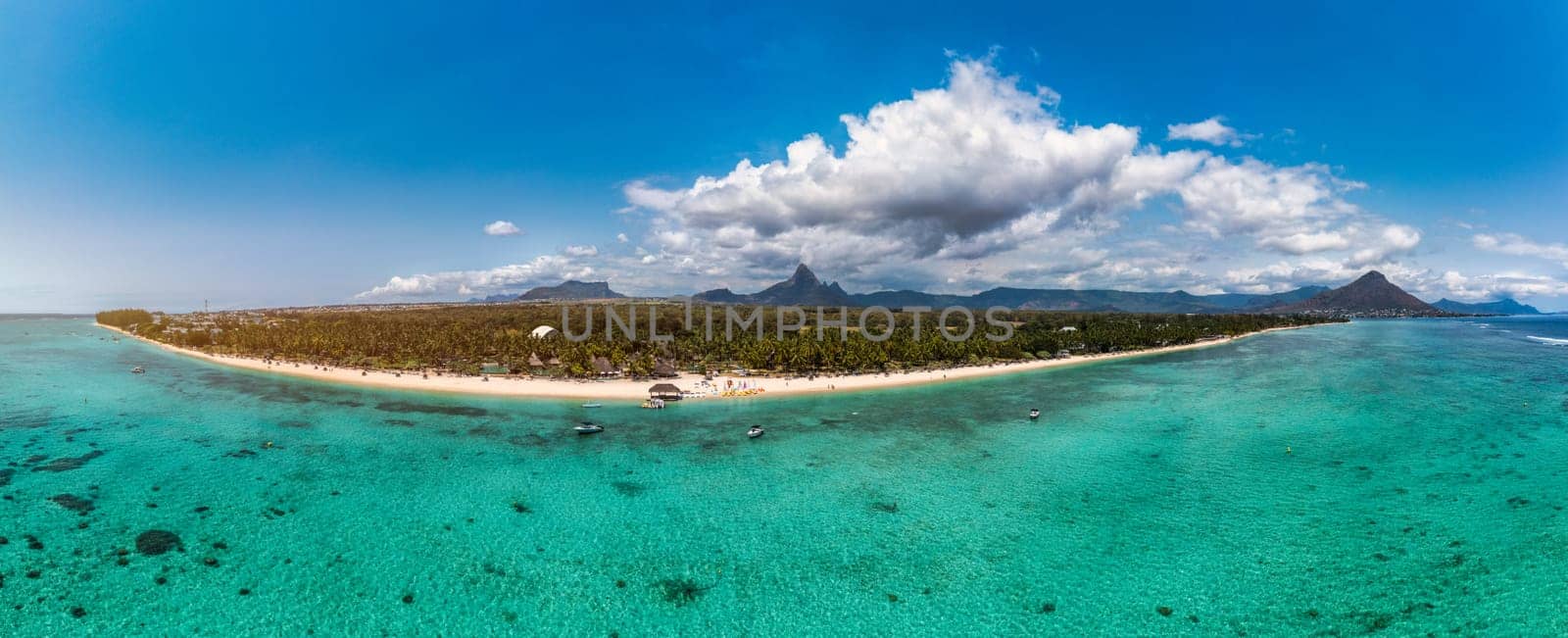 Beach of Flic en Flac with beautiful peaks in the background, Mauritius. Beautiful Mauritius Island with gorgeous beach Flic en Flac, aerial view from drone. Flic en Flac Beach, Mauritius Island.