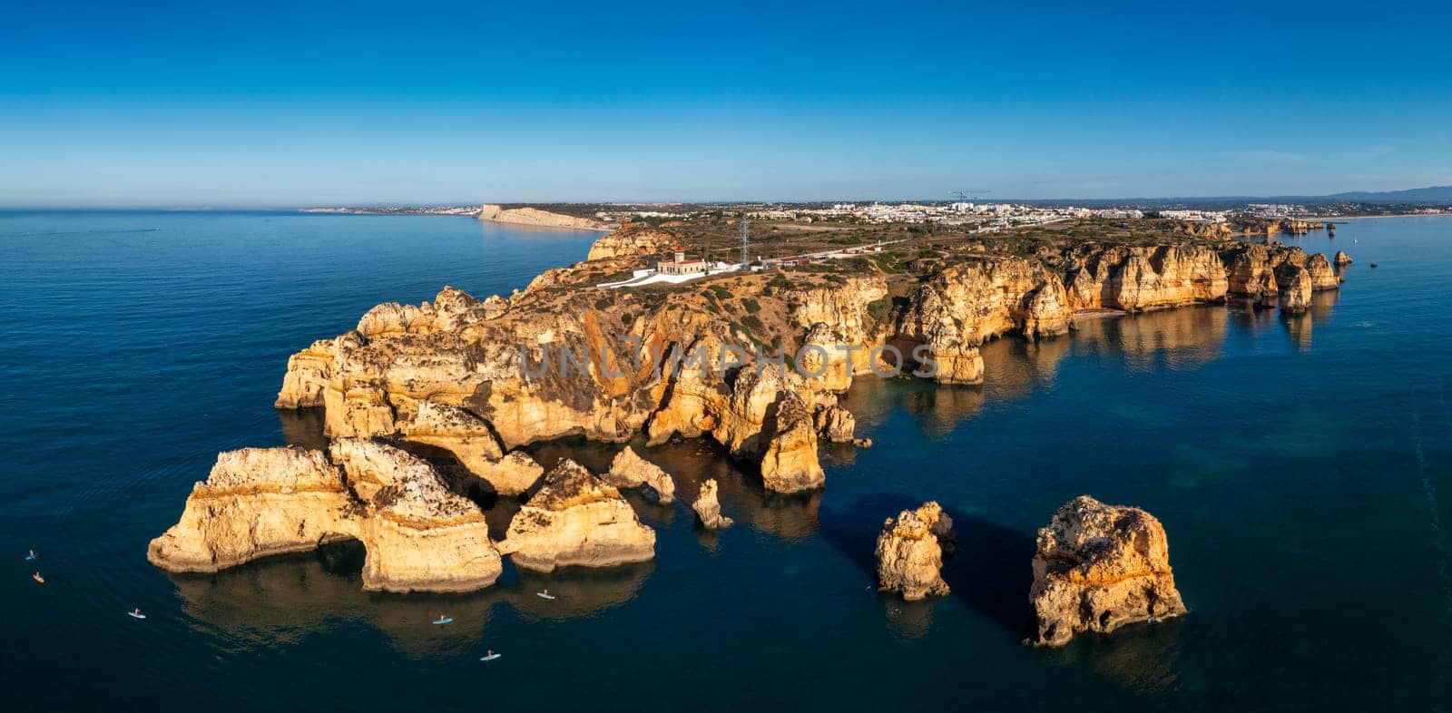 Panoramic view, Ponta da Piedade near Lagos in Algarve, Portugal. Cliff rocks and tourist boat on sea at Ponta da Piedade, Algarve region, Portugal. Ponta da Piedade, Algarve region, Portugal.