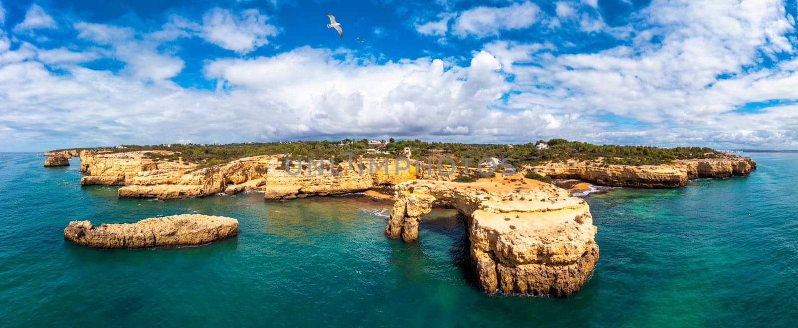 Natural arch above ocean, Arco de Albandeira, Algarve, Portugal. Stone arch at Praia de Albandeira, Lagoa, Algarve, Portugal. View of the natural arch Arco da Albandeira in the Algarve, Portugal.