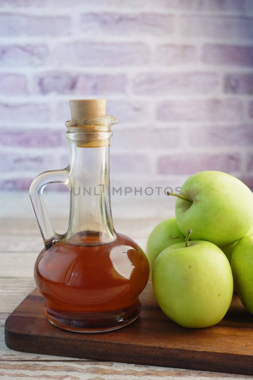 apple vinegar in glass bottle with fresh green apple on table ,