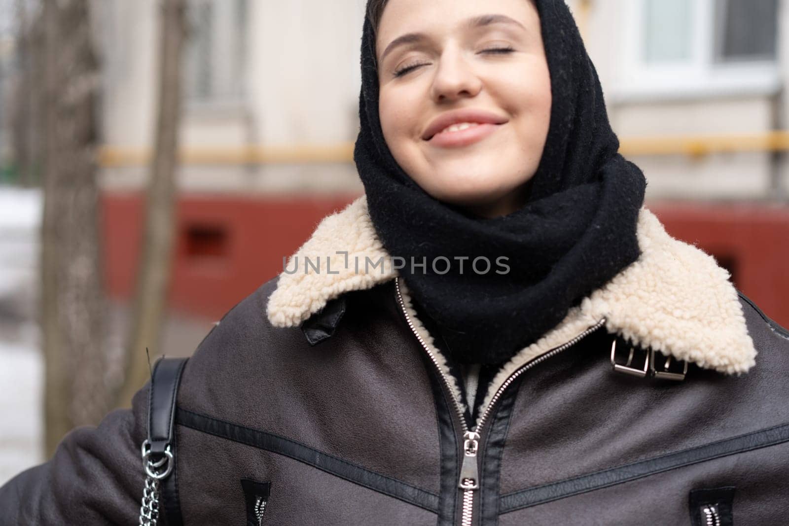 portrait of a young beautiful woman in a headscarf in winter outside