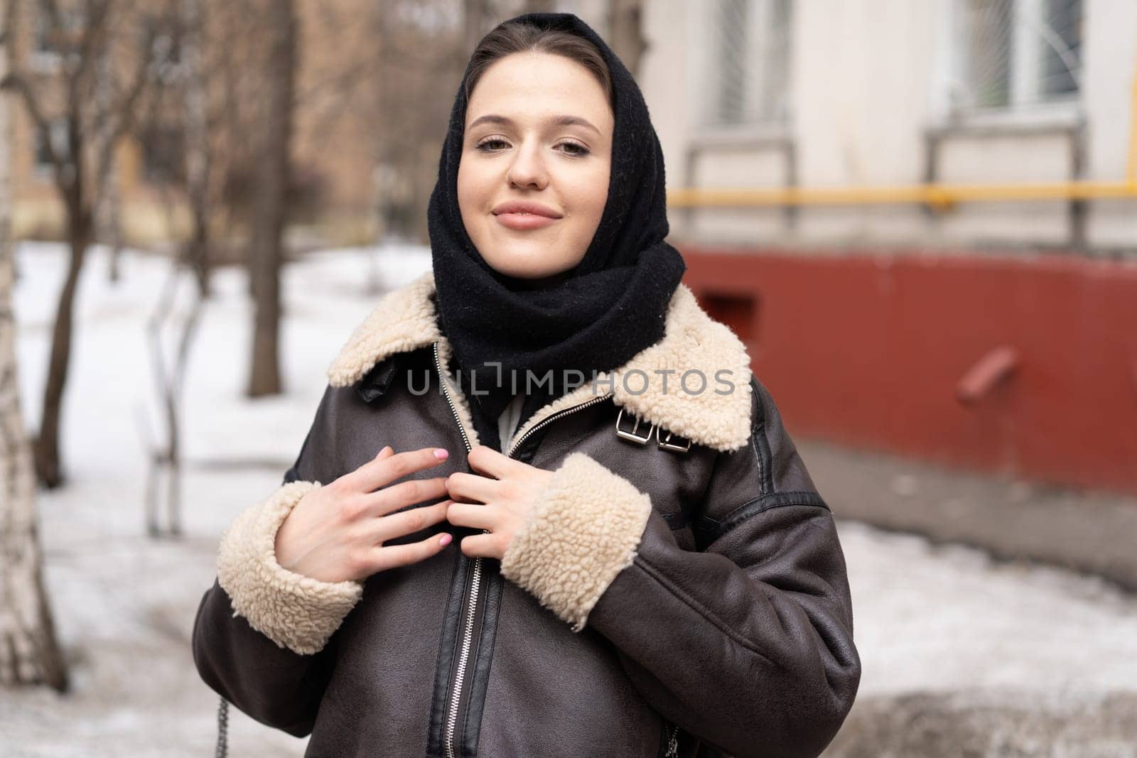 portrait of a young beautiful woman in a headscarf in winter outside