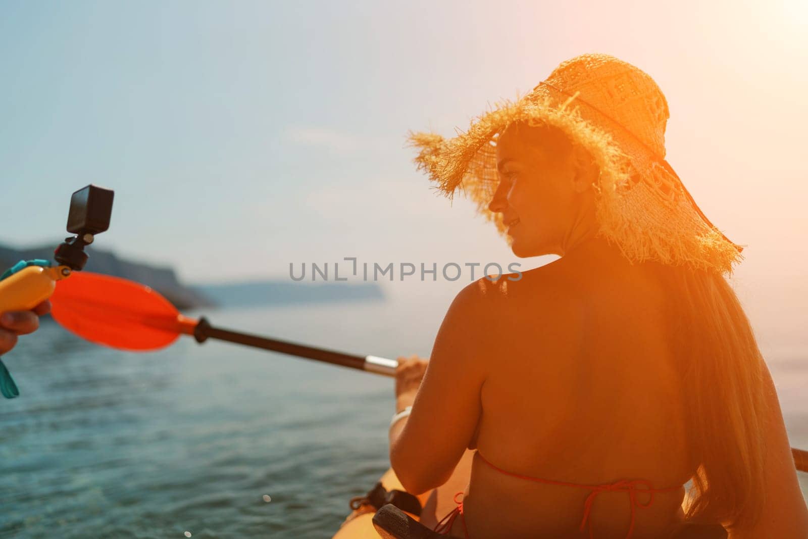 A woman wearing a straw hat is paddling a canoe on a sunny day. Scene is relaxed and carefree, as the woman enjoys her time on the water. by Matiunina