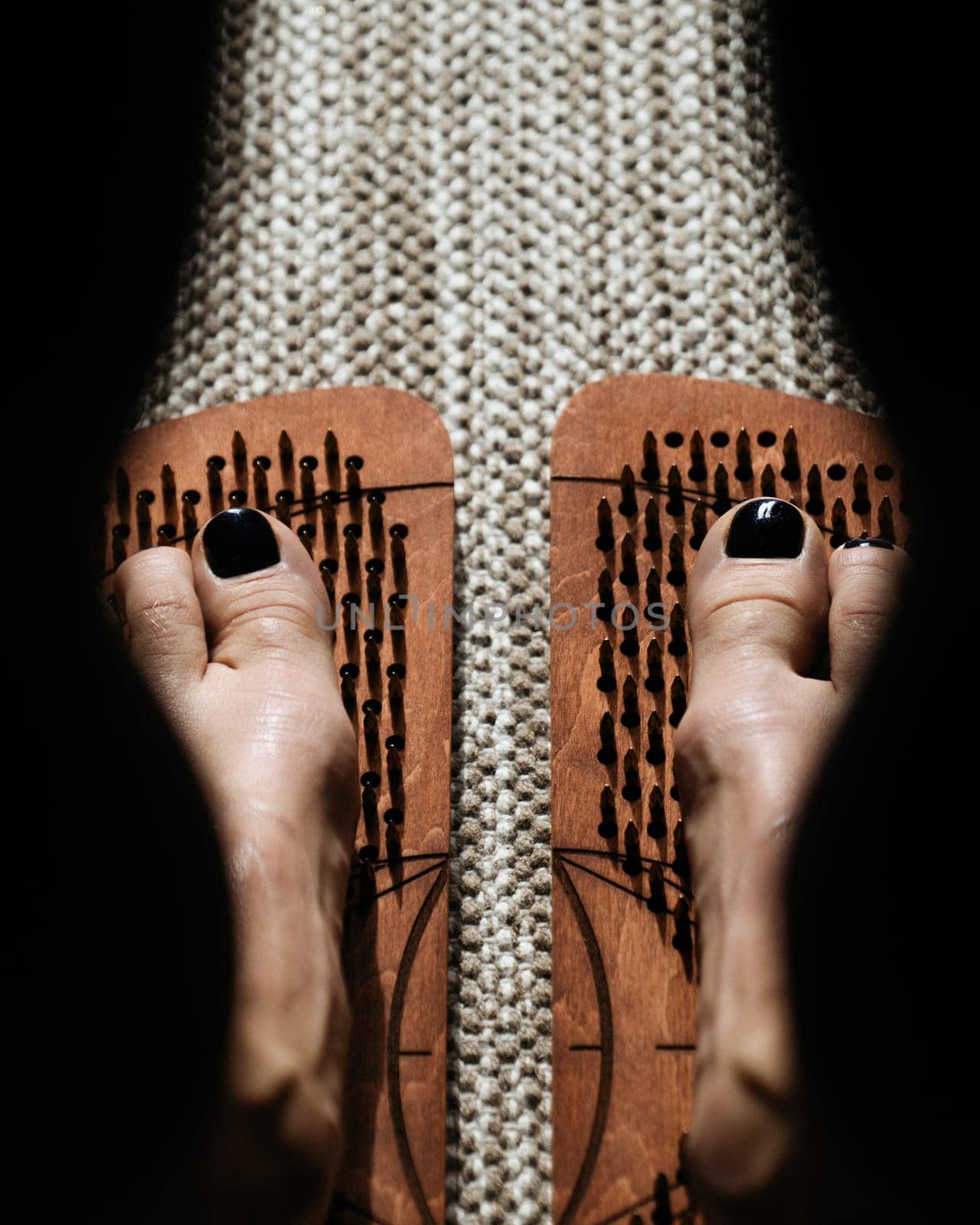 Shadow and light play over wooden acupressure boards with protruding pegs by apavlin