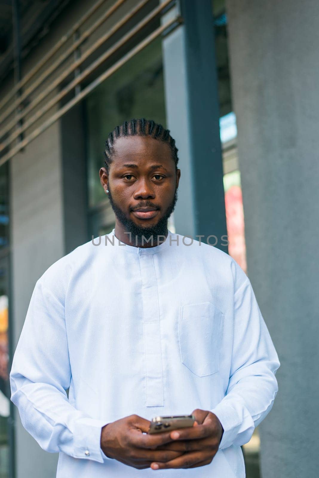 Cheerful male tourist portrait dress in white wear dashiki ethnic smiling at city street or small town background. African American travel model have free time. Millennial generation and gen z people.