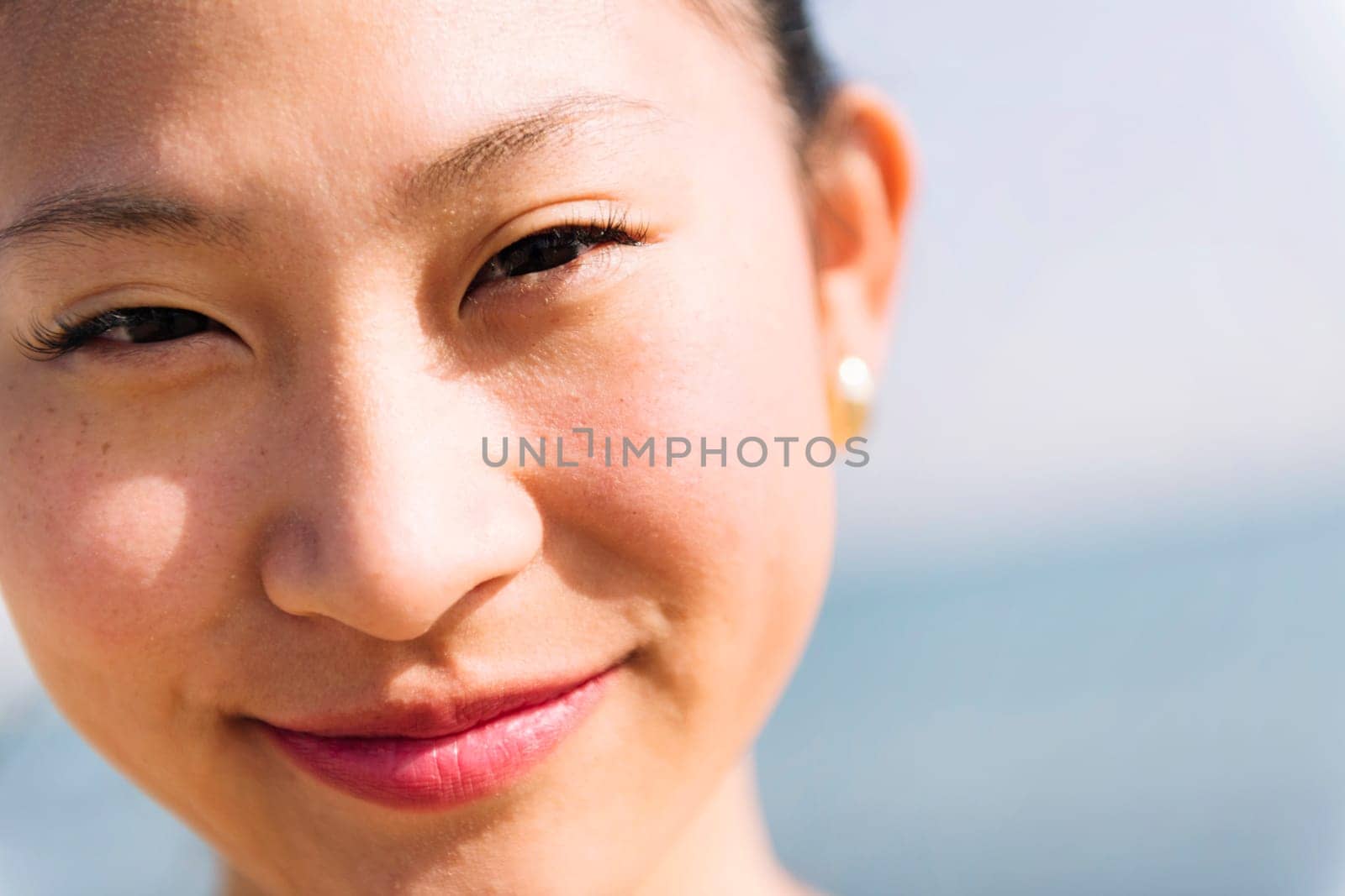 close up portrait of a cute asian woman smiling happy looking at camera, concept of beauty and purity