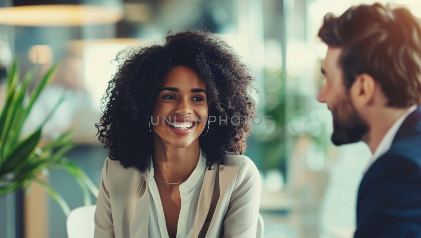 Happy two business people discussing a new project together in an office, professionals african smiling colleagues having a conversation at a meeting
