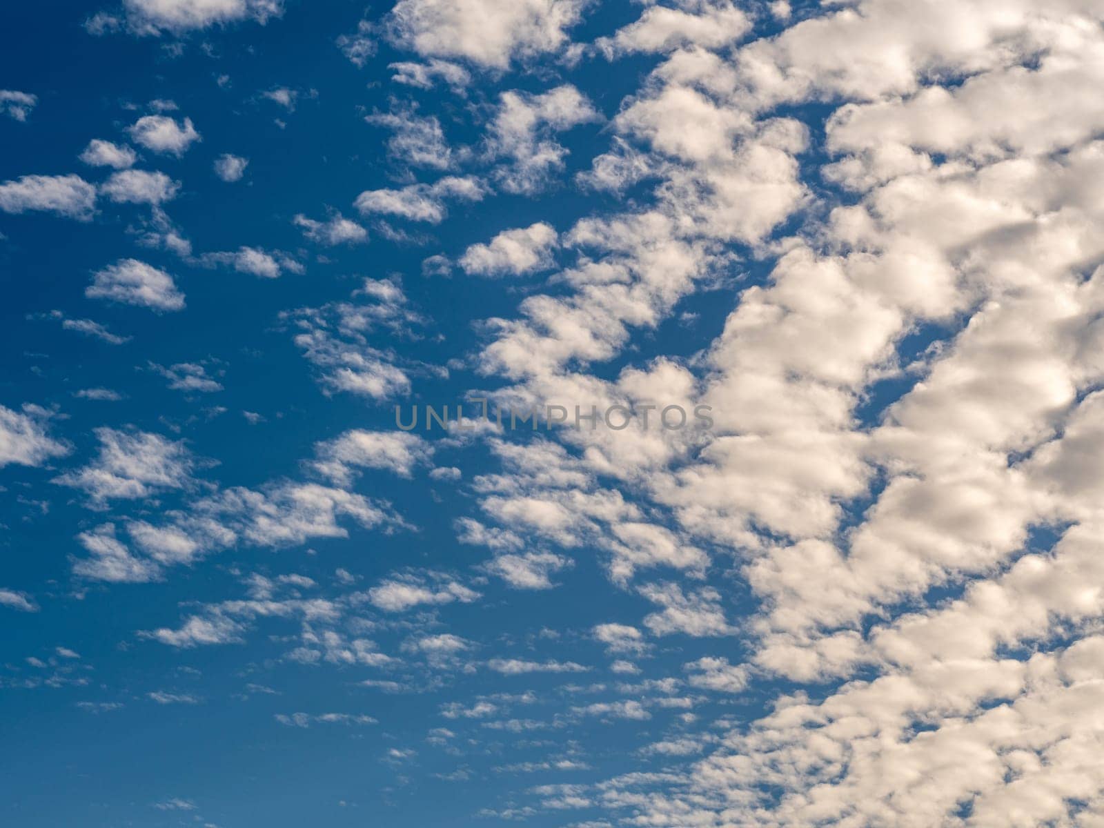 White fluffy clouds in the blue sky with morning light from the sunrise