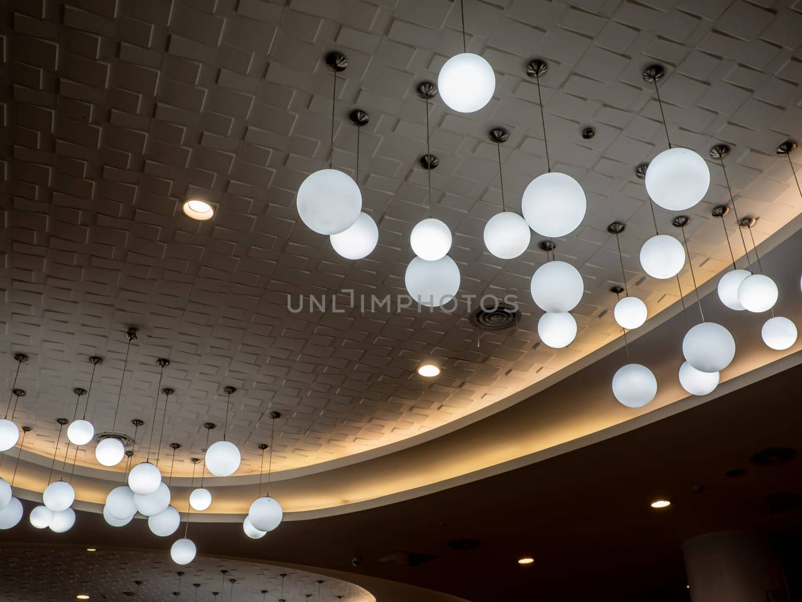 Round lamp hanging alternating high and low decorating the ceiling by Satakorn