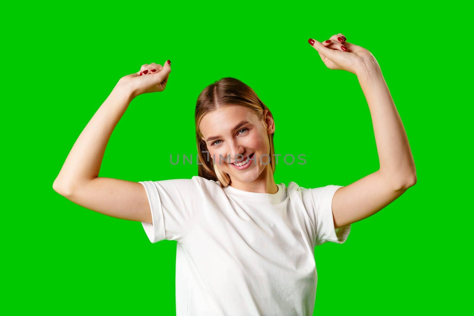 Happy Young Woman Raising Fists against green background by Fabrikasimf