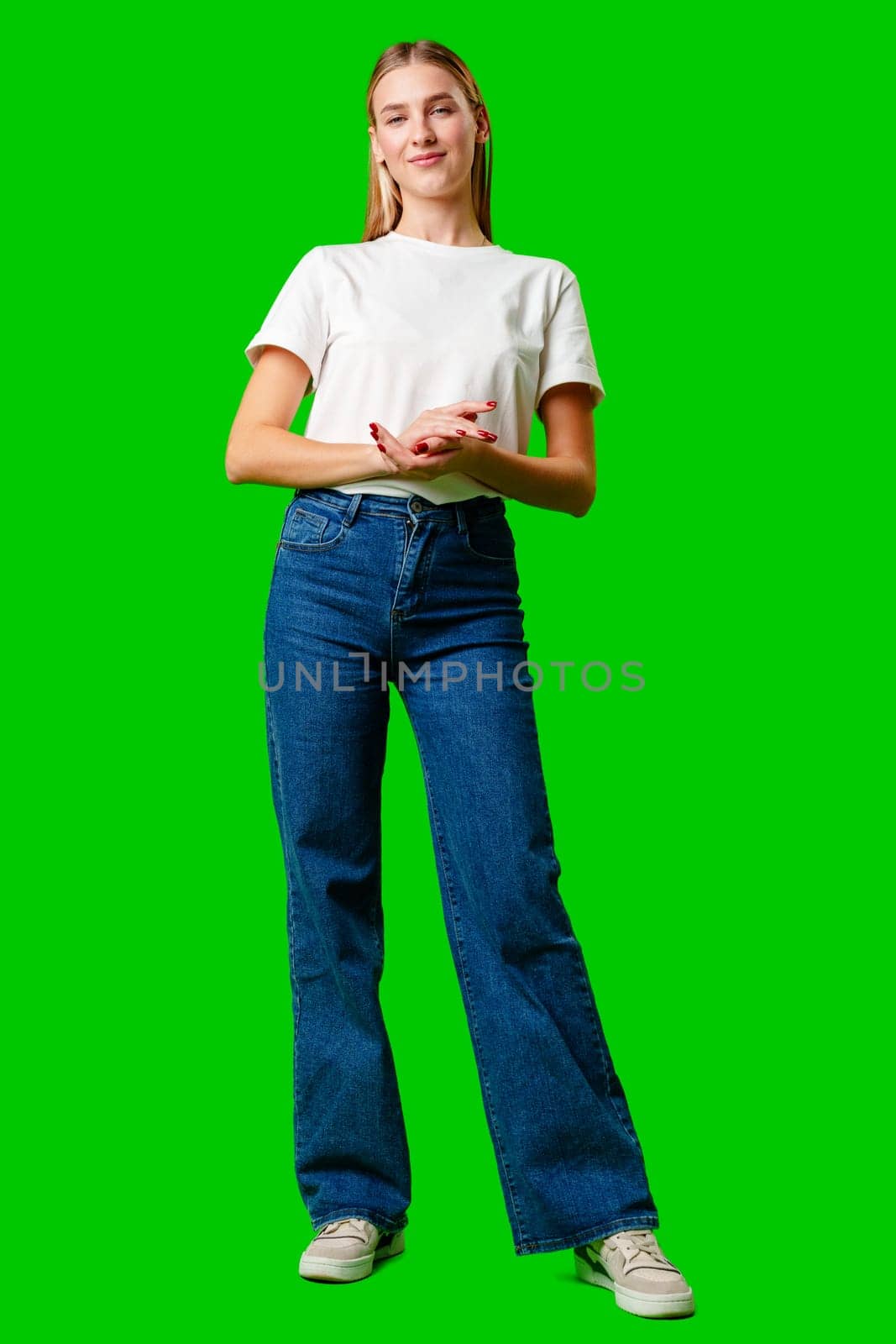 Young Woman in White Shirt Posing for Picture against green background in studio