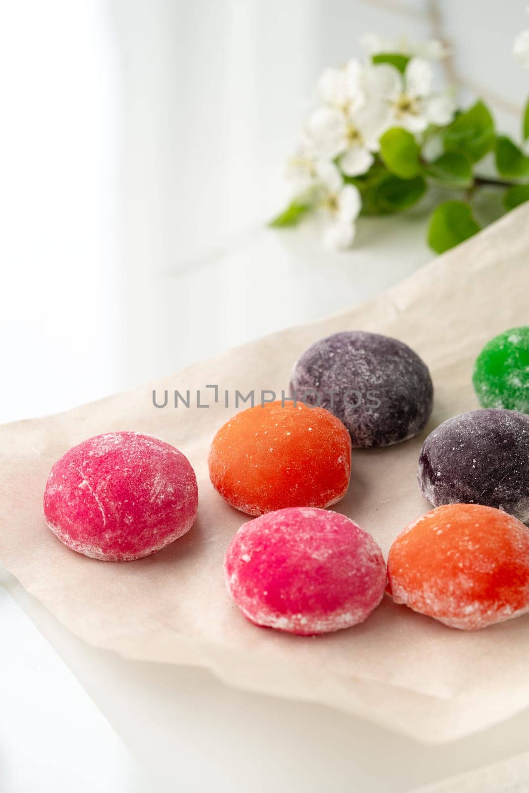 Multi-colored Japanese cakes Mochi in a white plate by Fabrikasimf