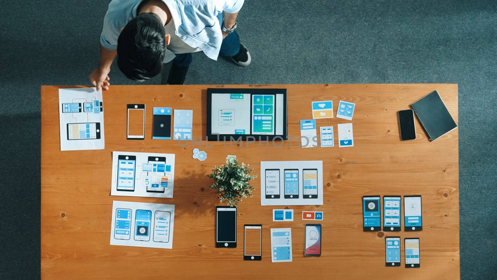 Top view of business man looking and choosing Ux Ui design at meeting room. Skilled developer designing and planning mobile phone interface or software application at creative workplace. Convocation.