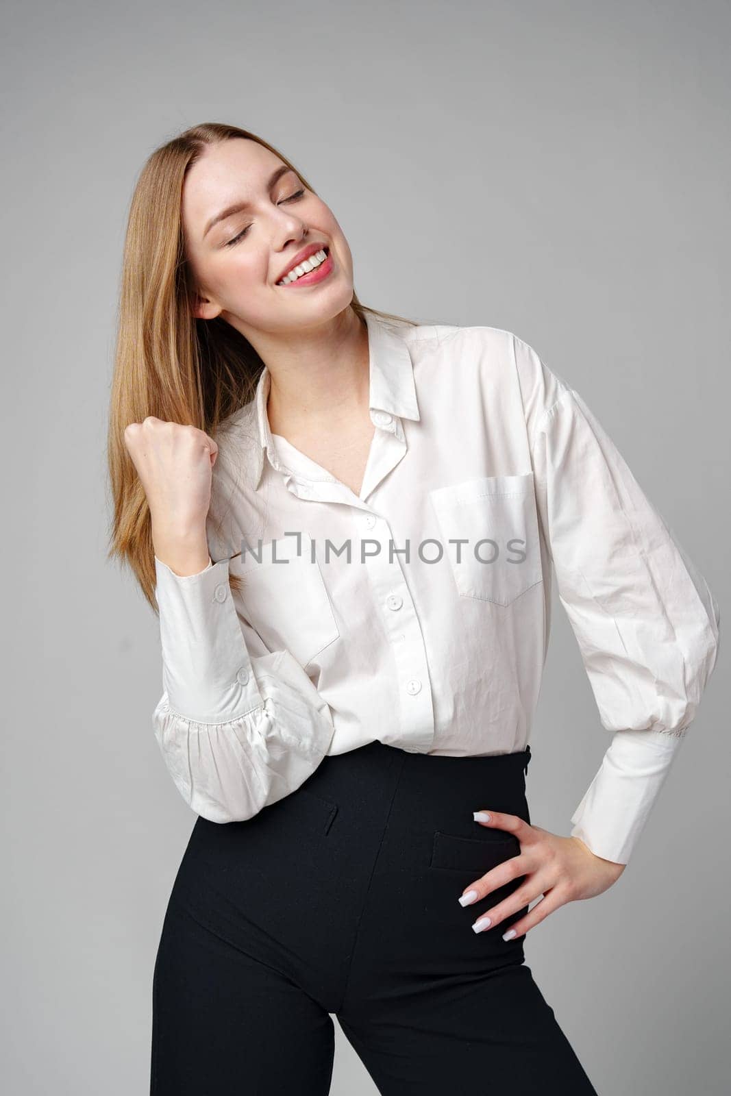 Jubilant Young Woman Celebrating a Victory With a Raised Fist in a Studio