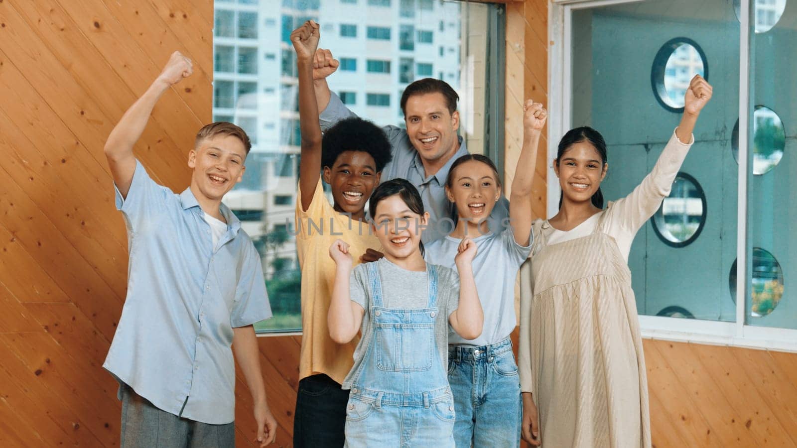 Smart teacher and diverse student standing while waving hand to camera. Skilled instructor with highschool children with mixed races in casual outfit greeting and smiling with cheerful. Edification.