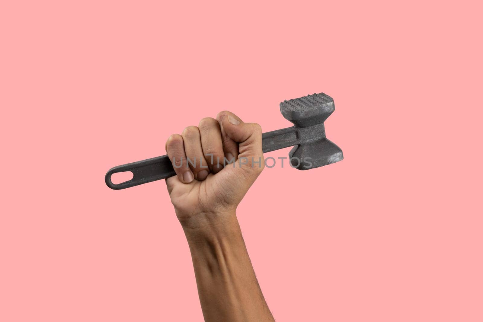 Black male hand holding a kitchen hammer isolated on pink background by TropicalNinjaStudio