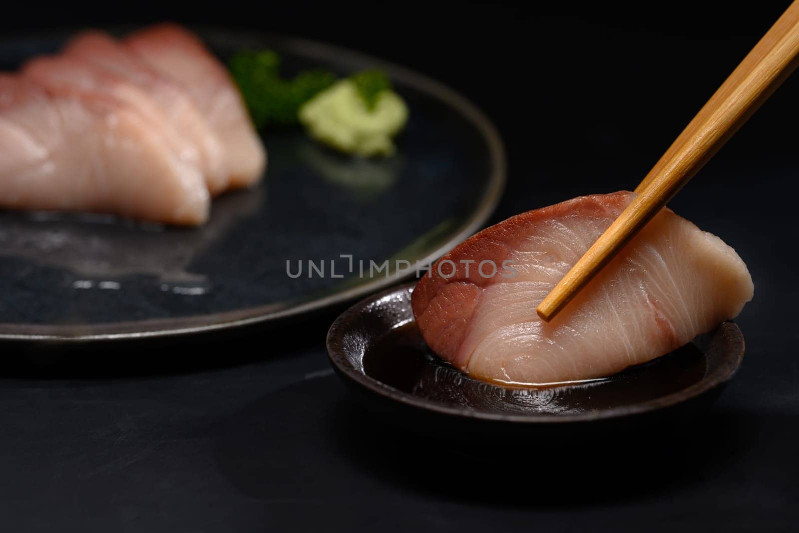 Close up pickled mackerel served with wasabi and soy sauce on black background by prathanchorruangsak