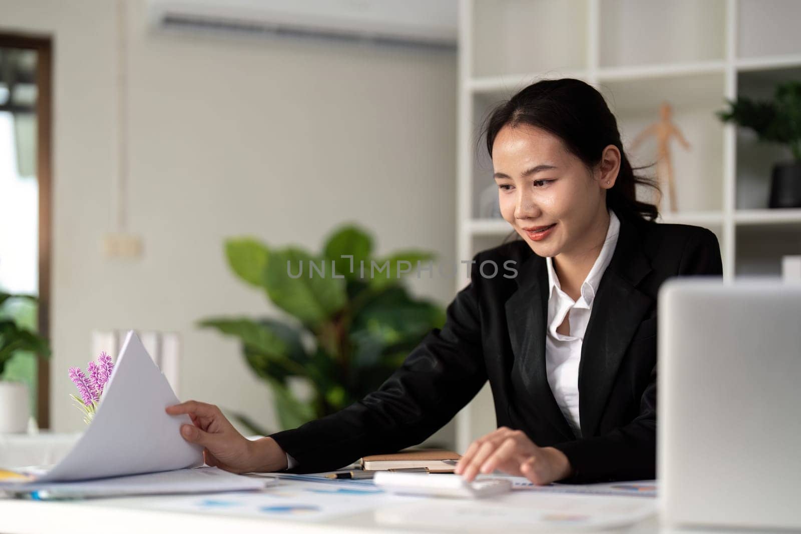 Young business woman asian or employee accounting bookkeeping documents checking financial data or marketing report working in office with laptop. Paperwork management.